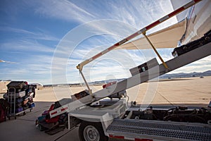 Luggage is being loaded in a passenger plane on a tarmac. Beautiful day at the airport with dramatic clouds.