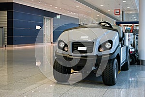 Luggage and disabled people carrying vehicle inside international airport terminal parked no people