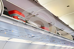 Luggage overhead compartment with hand-luggage in airplane or aircraft cabin interior