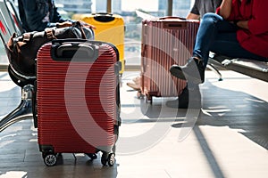 luggage and passengers sit on waiting seat in airport
