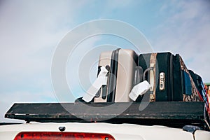 Luggages and Bags arranged on the car roof ready for a trip in sky background