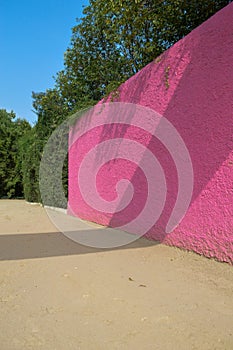 Luis Barragan`s Cuadra San Cristobal pink wall, endemic vegetation and sandy ground in the background photo