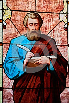 Luke, Mark, John, or Mathew apostle saint holding Christian bible book and quill church window