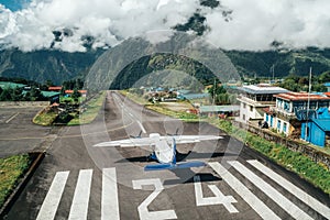 Lukla, NEPAL - October 18, 2019: Twin-engine short-range plane landing at the runway of world`s most dangerous airport in Lukla,