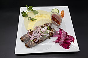 Lula kebab.Kebab.Traditional Oriental dish, barbecue shish kebab. Lamb, onions, cabbage, mashed potatoes spicy tomato sauce on pla