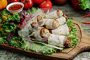 Lula kebab in lavash with pomegranate and onion on a wooden Board