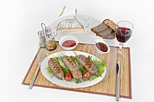 Lula kebab with tomatoes and cucumbers. Serve with black or white bread and a glass of red wine.