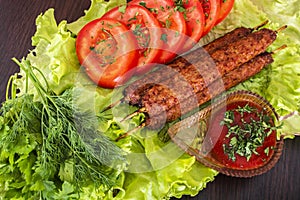Lulia kebab on a salad with tomatoes and dill photo
