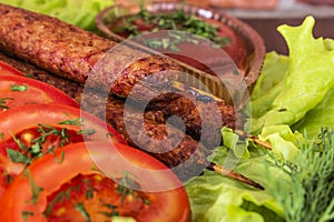 Lulia kebab on a salad with tomatoes and dill photo