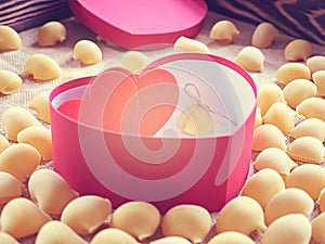 lumakoni pasta in heart shaped gift box. Valentine\'s Day. There are two hearts in an open box and a lot of raw pasta around.