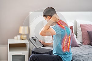 Lumbar and cervical spine hernia, man with back pain at home searches the Internet for symptoms of the disease, online medicine