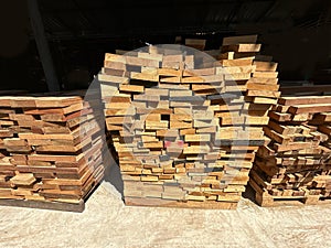 Lumber planks stack in the sawmill. Stacked of woods on ground in furniture factory