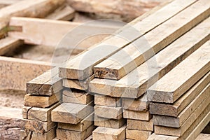 Lumber stack of natural rough wooden boards on building site