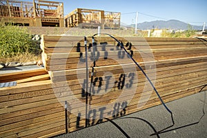 Lumber stacked at a housing construction site with framed structures in the background