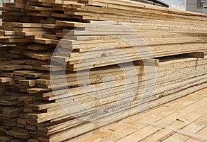 Lumber warehouse. Long wood planks stacked outdoors