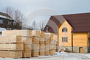 Lumber warehouse in the open air. Wooden beam, planks of wood, stacked in stacks. Construction material