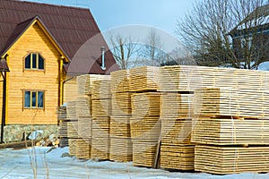 Lumber warehouse in the open air. Wooden beam, planks of wood, stacked in stacks. Construction material