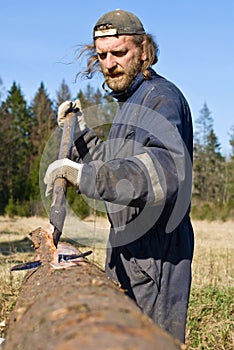 Lumber worker peeling bark