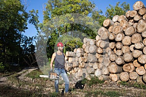 Lumberjack with chainsaw and ax in forest