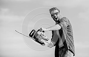 Lumberjack with chainsaw in his hands. Masculinity concept. Sharp blade. Dangerous job. Feeling manly. Powerful chainsaw