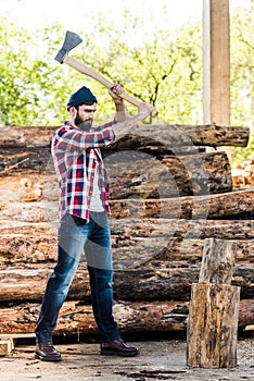 lumberjack in checkered shirt chopping log photo