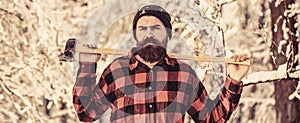 Lumberjack concept. Lumberjack man working in the winter forest. Hipster woodsman concept. Man in hat with beard and