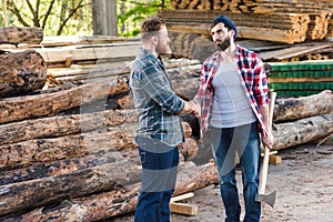 lumberjack with holding axe and shaking hands with partner
