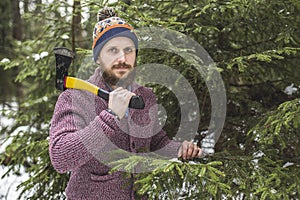 Lumberjack near the christmas tree in forest