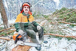 Lumberjack portrait cutting tree in snow winter forest