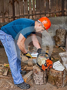 Lumberjack refilling his chainsaw