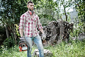 Lumberjack or woodcutter moving and looking with chainsaw photo