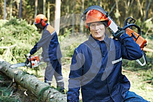 Lumberjack worker with chainsaw in the forest