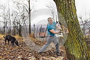 Lumberjack worker chopping down a tree breaking off many splinters in the forest with big axe. photo