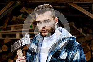 Lumbersexual concept. Bearded lumberjack checkered clothes carry axe. Sharp blade. Brutal man collects firewood. Hipster
