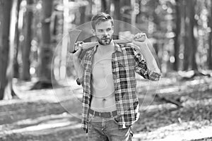 Lumbersexual trend. Bearded man carry axe natural landscape. Sexy guy wear open plaid shirt with masculine look