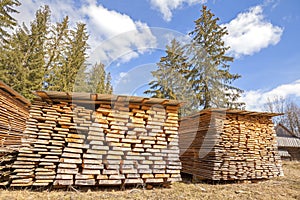 Lumberyard with canopied boards piles in a forest.