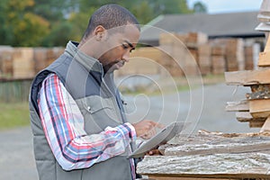 Lumberyard clerk inspecting products