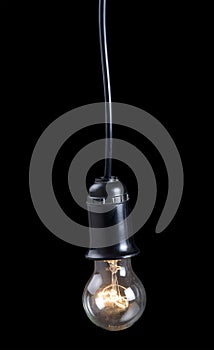 Luminescent electric lamp in receptacle on black photo