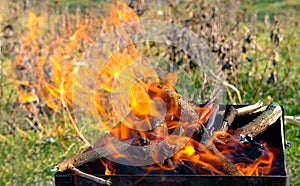 Luminous coals in a grill for a barbecue in the open air, outdoors.. Burning wood and coal in a barbecue