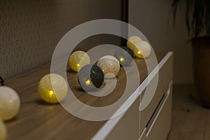 Luminous decorative round lanterns of different colors on a shelf
