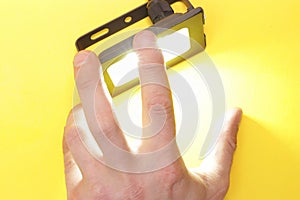 Luminous diode floodlight that holds a male hand. Lighting device. Modern energy-saving technologies. Copy space for text