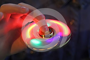 Luminous fidget spinner in hand. Popular trendy toy close-up.