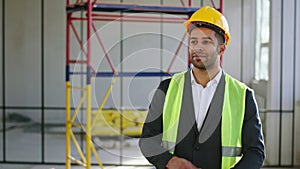 In the luminous industrial building charismatic man architect walking to the camera then posing smiling large and