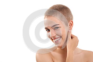 Luminous skin. Portrait of a beautiful and positive blond woman with short hair and nude make up touching her face with