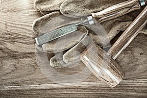 Lump hammer flat chisel protective gloves on wood board