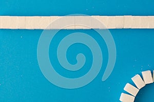 Lump sugar stripe on blue background with copy space