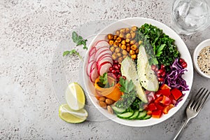 Lunch bowl salad with avocado, roasted chickpeas, kale, cucumber, carrot, red cabbage, bell pepper and redish