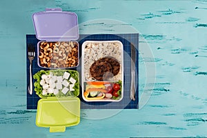 Lunch box with appetizing food and on light wooden table