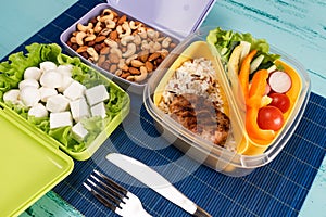 Lunch box with appetizing food and on light wooden table