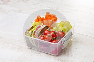 Lunch box with fresh vegetables and fruits.